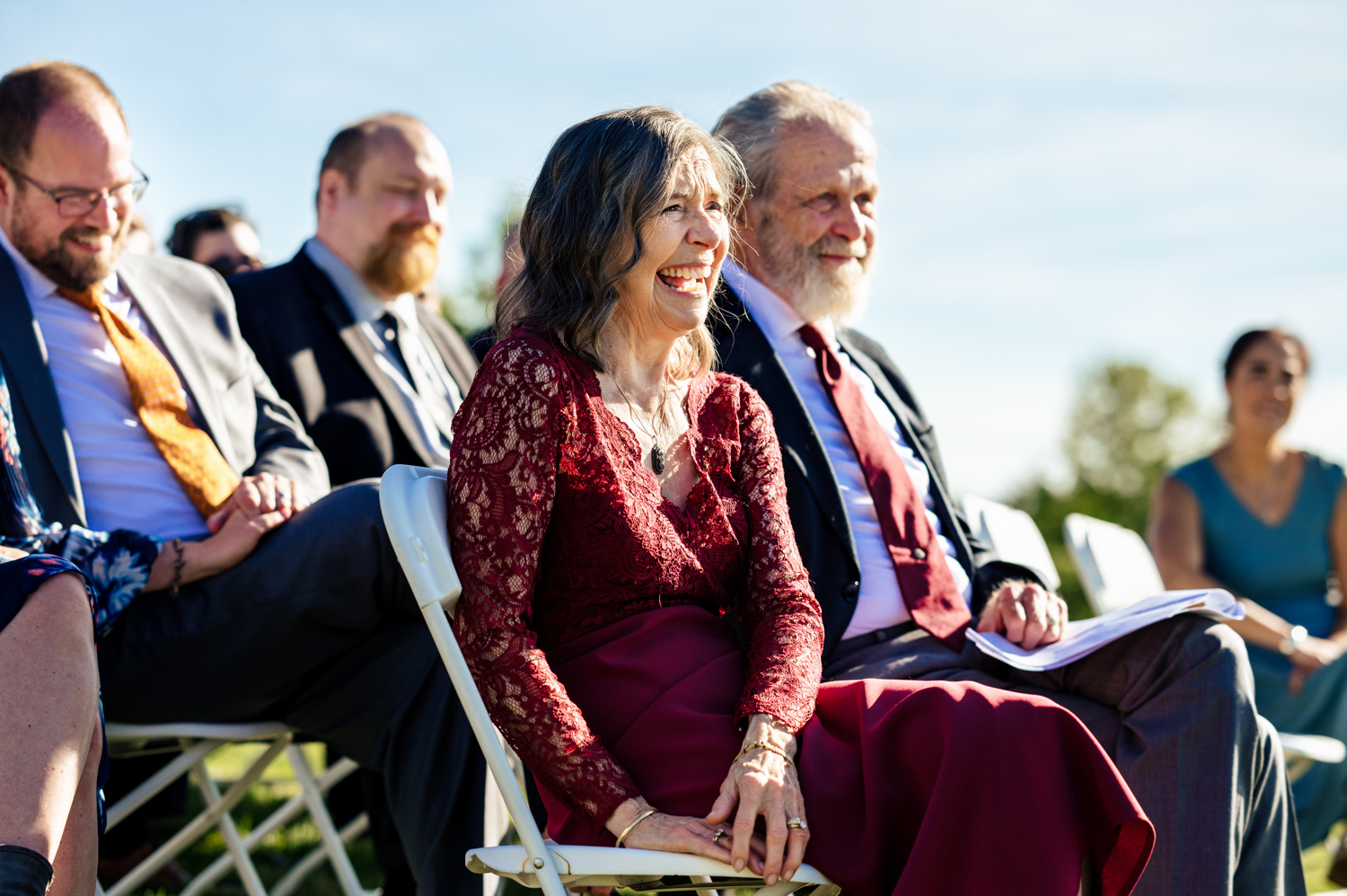 Guests laughing delightedly during wedding ceremony in East Burke, Vermont.